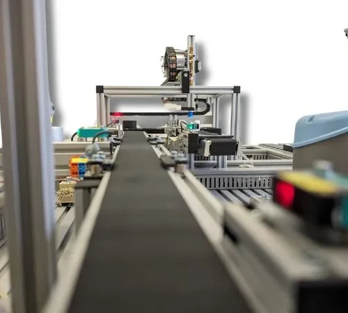 Fragment przenośnika taśmowego Zdjęcie obrazujące fragment przenośnika taśmowego pomiędzy magazynem wysokiego składowania a magazynem powierzchniowym.